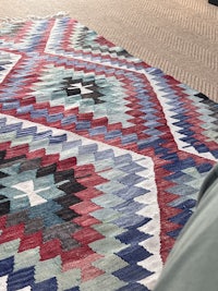 a colorful kilim rug on the floor of a room